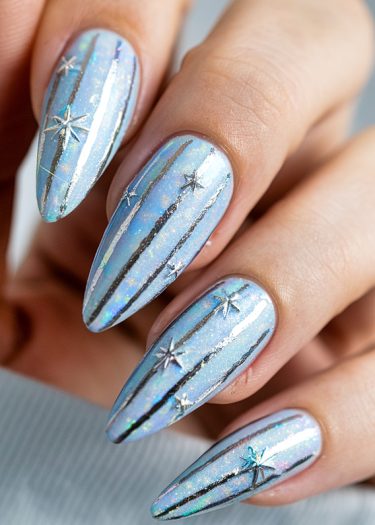 Elegant iridescent blue nails with silver lines and star embellishments for a futuristic look.