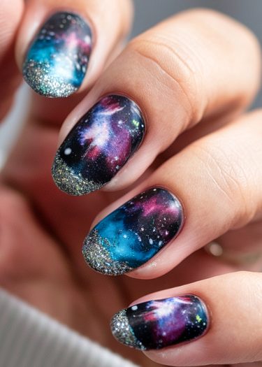 Stunning galaxy nail art design with vibrant cosmic colors and sparkling glitter tips.