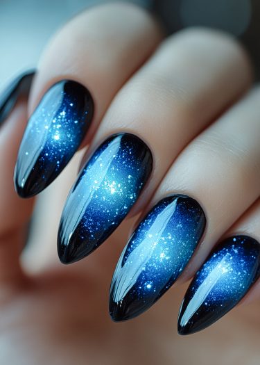 Galaxy-themed nail art featuring shiny, ombre nails with starry glitter details.