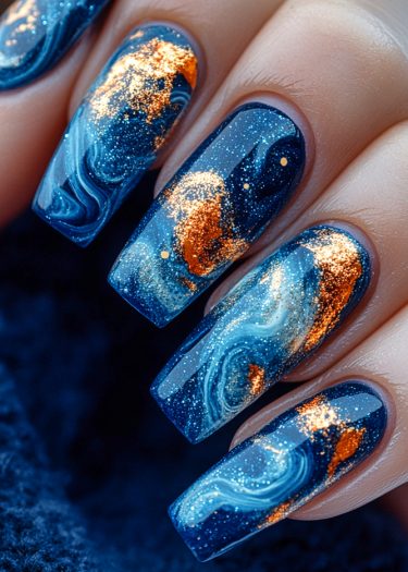 Stunning galaxy nail art featuring deep blues and golden accents for a cosmic look.