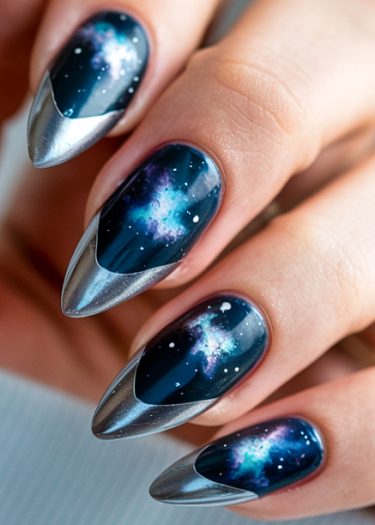 Galaxy stiletto nail art features deep blue colors and vibrant cosmic designs with star accents.