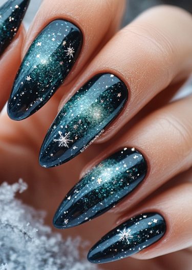 Elegant galaxy-themed stiletto nails with shimmering dark blue, teal, and starry accents.