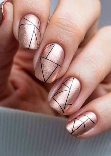 Elegant rose gold nails with black geometric designs for a trendy manicure.