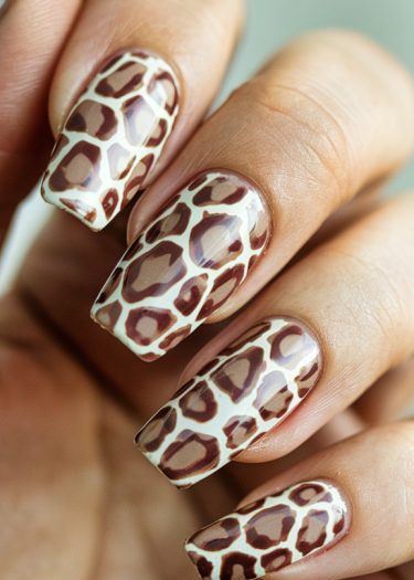 Giraffe print nail art showcases stylish, intricate designs on well-manicured nails.