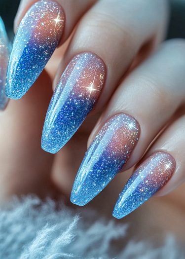 Exquisite ombre glitter gradient nails in pale pink and vibrant blue, showcasing luxurious manicure artistry.