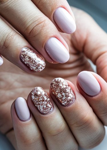 Elegant light mauve nails with rose gold glitter and floral accents for a sophisticated manicure.