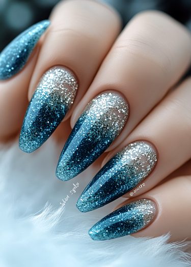 Elegant blue ombre nails with glitter accents for a chic manicure look.