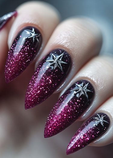 Stunning black-to-magenta gradient stiletto nails with glitter and metallic star embellishments.