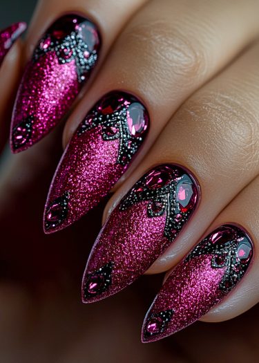 Dazzling stiletto nails in glittery magenta adorned with intricate black patterns and sparkling rhinestones.