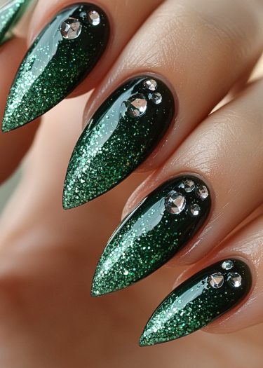 Stunning green stiletto nails with glitter and rhinestones for a glamorous look.