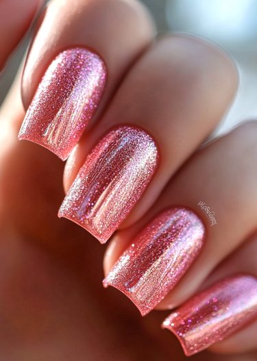 Stunning glittery pink nail design showcasing elegant manicured nails with iridescent sparkles.