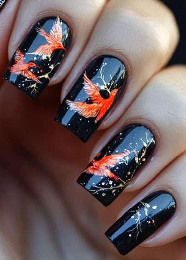 Elegant glossy black nail art featuring vibrant orange-red birds and shimmering gold accents.