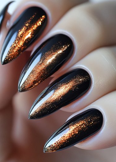 Stunning stiletto nails with glossy black base and shimmering copper gold glitter design.