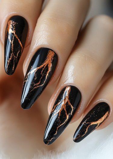 Elegant almond-shaped black nails with shimmering coppery gold lightning design for a sophisticated manicure.