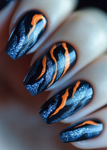 Impeccably designed glossy black nails with vibrant orange and blue glitter flame patterns.