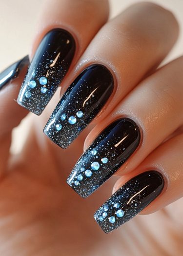 Elegant black nails with glitter and rhinestones for a stunning, glamorous look.