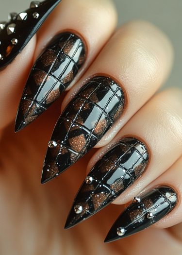 Intricate stiletto manicure with glossy black polish and geometric metallic accents.