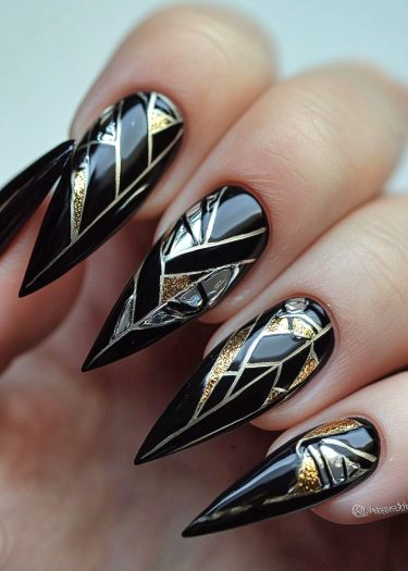 Elegant glossy black stiletto nails with intricate gold and silver geometric designs.