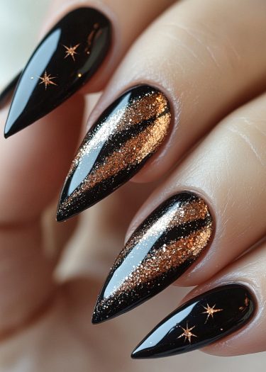 Gorgeous glossy black stiletto nails with gold and copper glitter designs and star motifs.