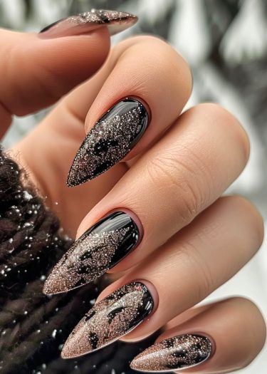 Elegant stiletto nails with glossy black base and rose gold glitter gradient design.