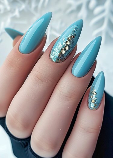 Elegant glossy blue stiletto nails with intricate gold accents and glitter details.