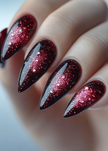 Elegant stiletto nails with glossy deep red polish and shimmering glitter for a sophisticated look.