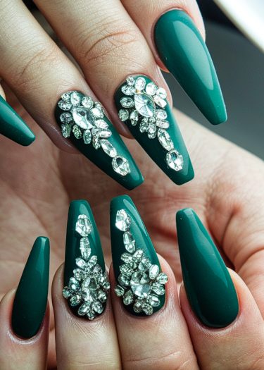 Elegant almond-shaped green nails with stunning jewel embellishments for a luxurious manicure.