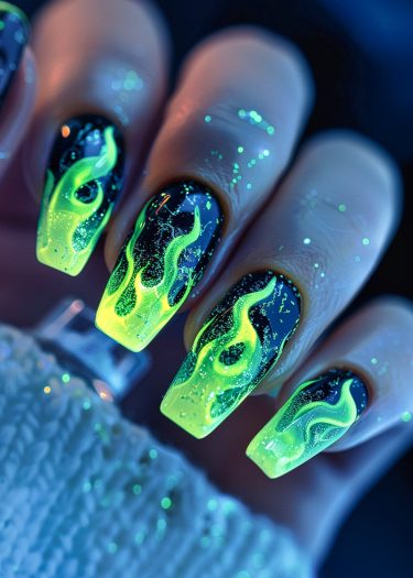 Vibrant black and neon green flame nail art for a bold, edgy manicure look.