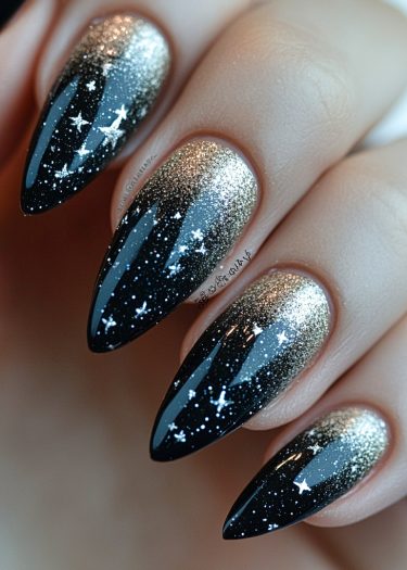 Elegant almond-shaped nails featuring a stunning black and gold gradient with cosmic designs.