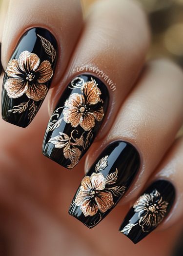 Glossy black nail art featuring intricate gold floral designs and stunning metallic accents.