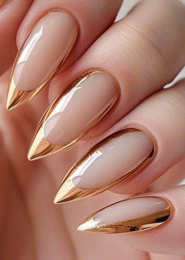 Elegant almond-shaped nails with gold tips and nude base for a sophisticated manicure.