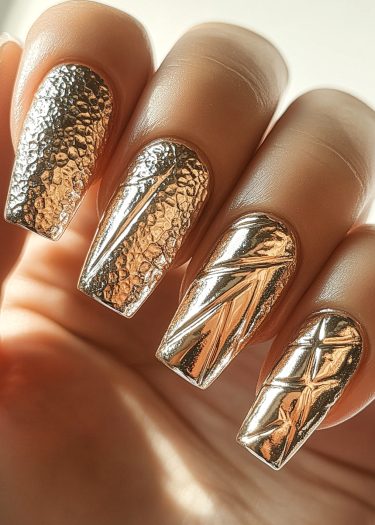 Elegant gold metallic nail art featuring intricate textured designs and luxurious shine.