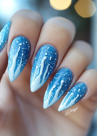 Stiletto nails with blue gradient, snowflake design, and bokeh lights create an elegant winter vibe.