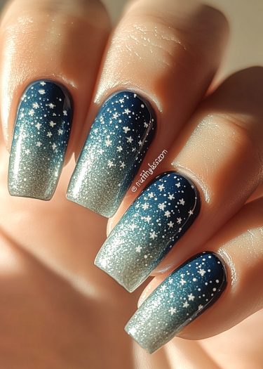 Cosmic gradient blue and silver nail art with starry designs and glossy finish.