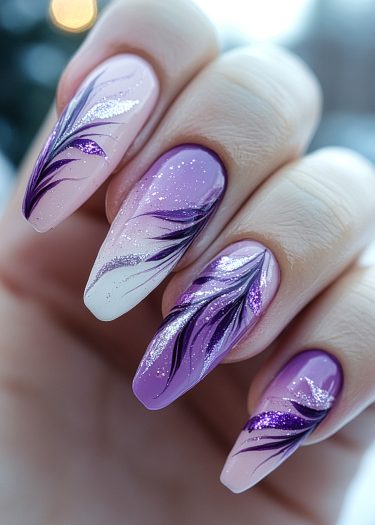 Elegant purple and pink gradient feather nail art with glitter accents for a sophisticated look.