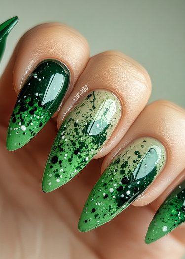 Vibrant gradient green stiletto nails with splatter art for a chic nail design.