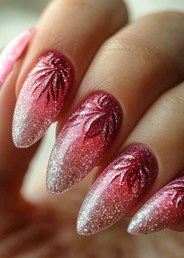 Elegant gradient pink nail art with glitter and intricate leaf designs on almond-shaped nails.