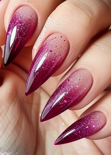 Stylish stiletto nails with a burgundy gradient and glitter for a glamorous manicure.