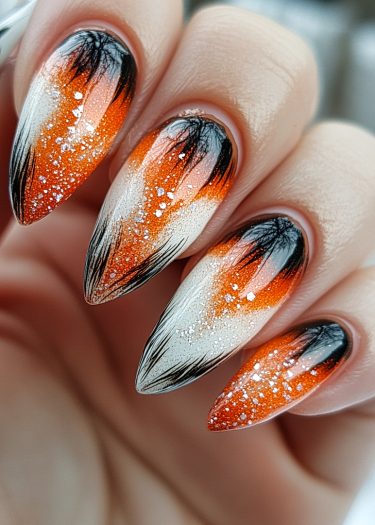 Vibrant orange and black gradient nail art with glitter for a stunning, elegant look.