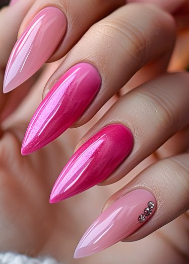 Stunning gradient pink stiletto nails with rhinestones and high-gloss finish, showcasing elegant nail art.