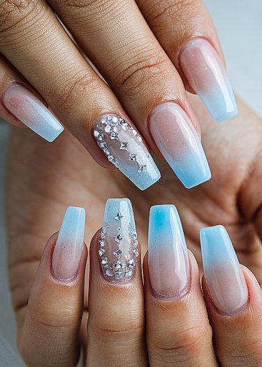 Elegant pink-blue ombre nails with rhinestones for a stylish manicure look.