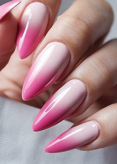 Elegant stiletto nails featuring a beautiful pink ombre gradient manicure.