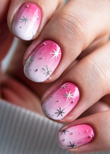 Gorgeous pink and white gradient nails with starburst designs for a stylish, elegant look.