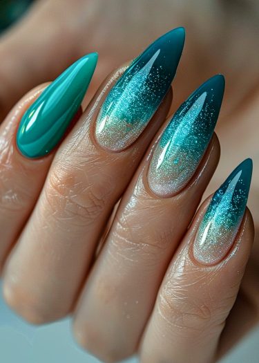 Elegant gradient teal stiletto nails with shimmering aqua sparkle for a stunning manicure look.