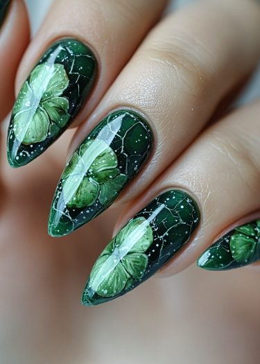 Elegant green stiletto nails with intricate leaf designs and glossy finish for luxurious nail art.