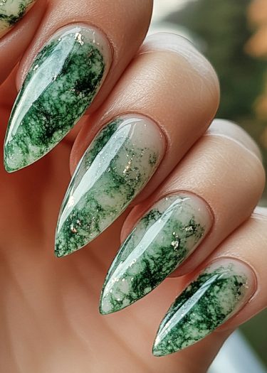 Elegant green marbled almond nails with glossy finish and gold accents, showcasing intricate nail art.