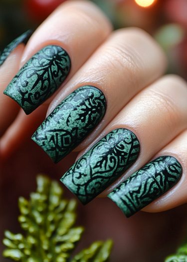 Elegant metallic green nail art with intricate black patterns for a chic, sophisticated look.