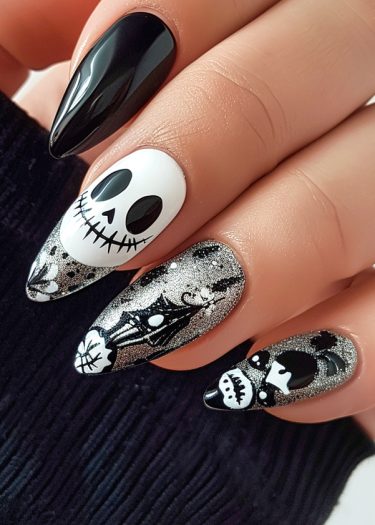 Stylish Halloween nail art with black, white, and silver designs on long almond-shaped nails.