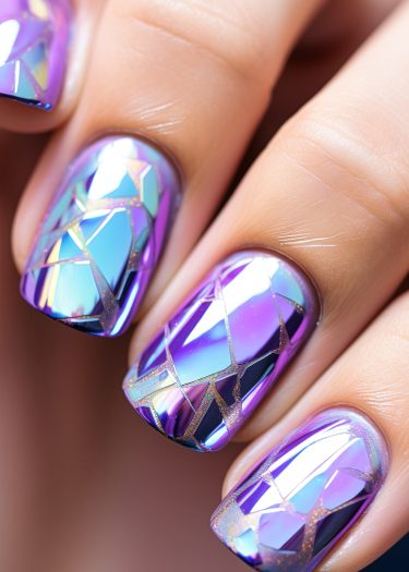 Vibrant holographic geometric nail art with shattered glass effect in purple and blue shades.