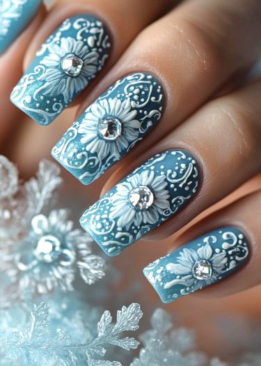 Elegant icy blue floral nail art with rhinestones, showcasing intricate designs and sophistication.